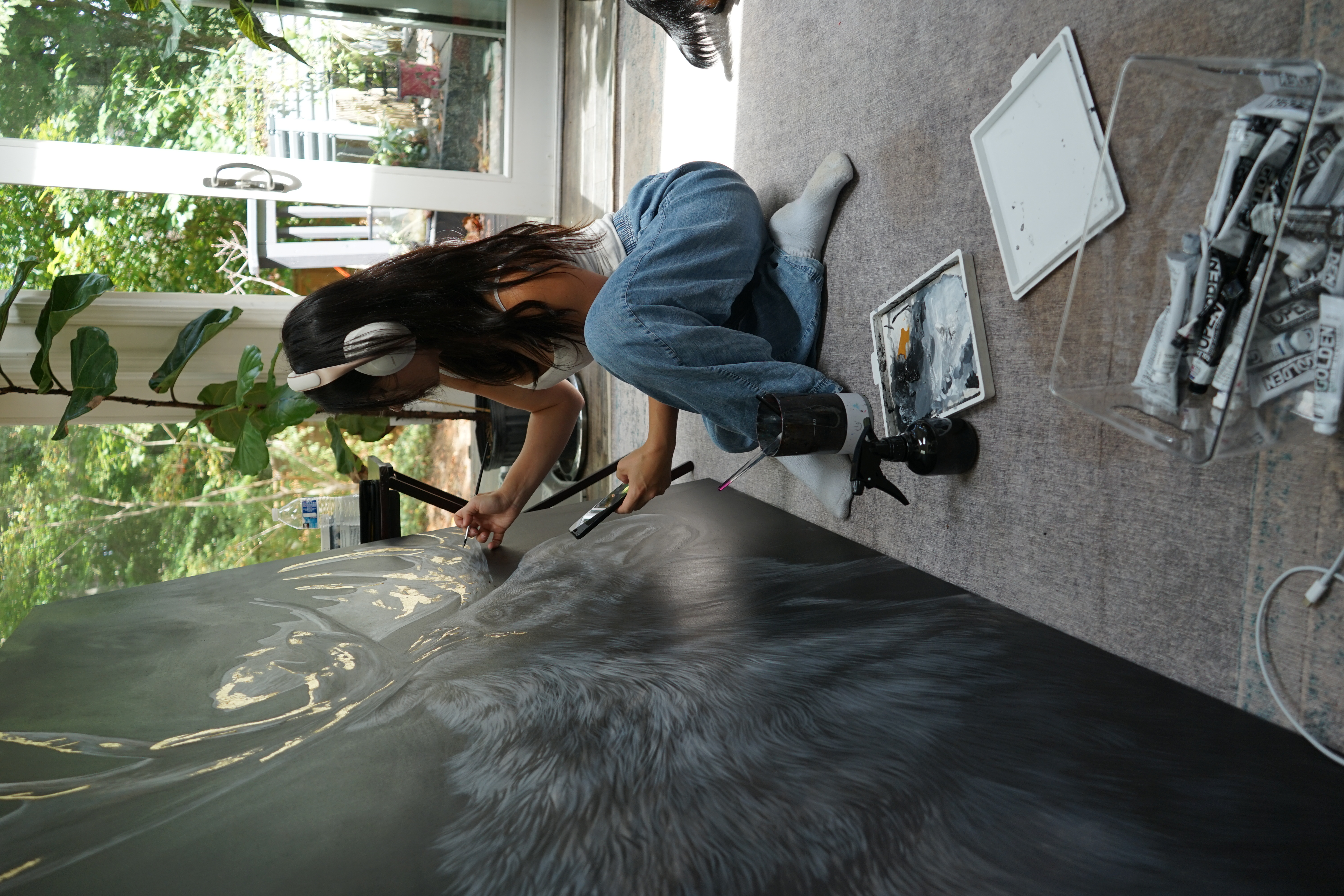 Ashley Rader painting a large moose artwork in her studio
